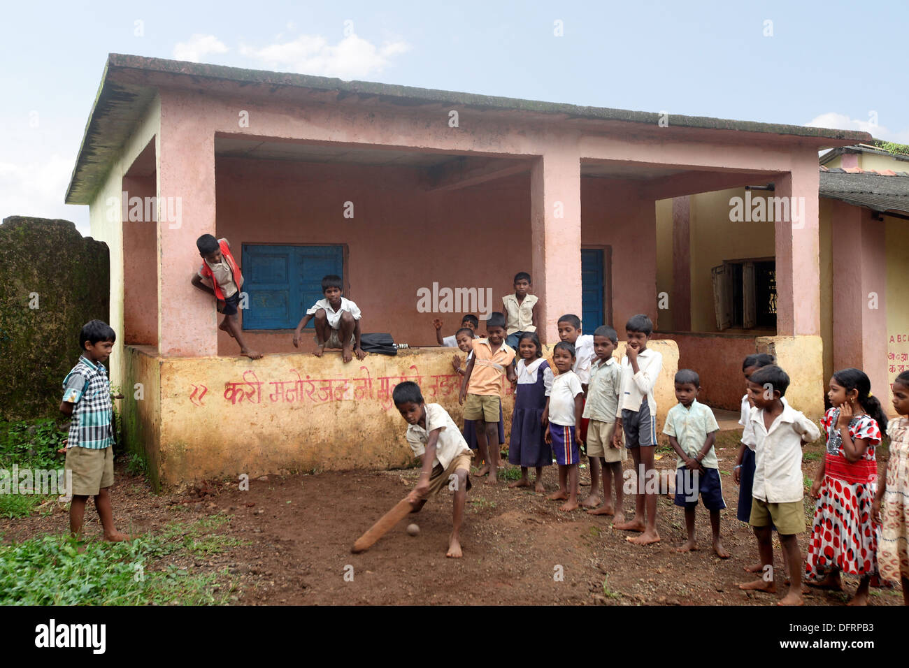 Katkari tribal children playing cricket in school campus, Maharashtra, India. Stock Photo