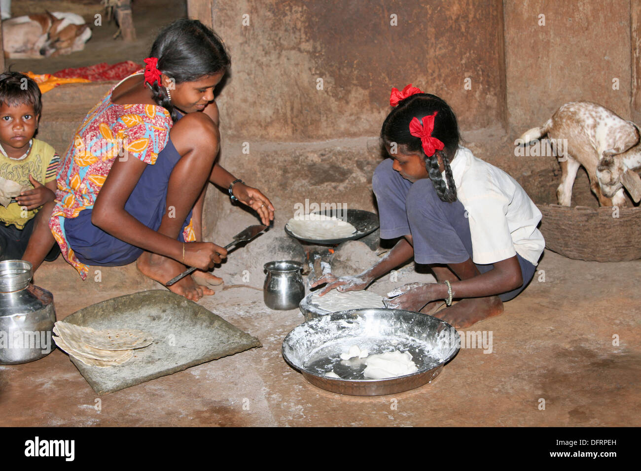 Katkari tribal girls making chapati, Karambali village, Maharashtra, India Stock Photo