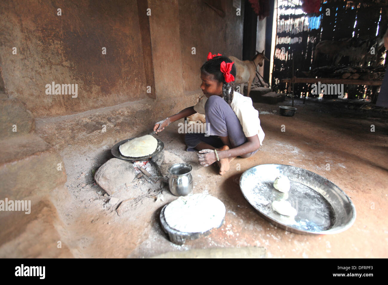 Katkari tribal girl making chapati, Karambali village, Maharashtra, India Stock Photo