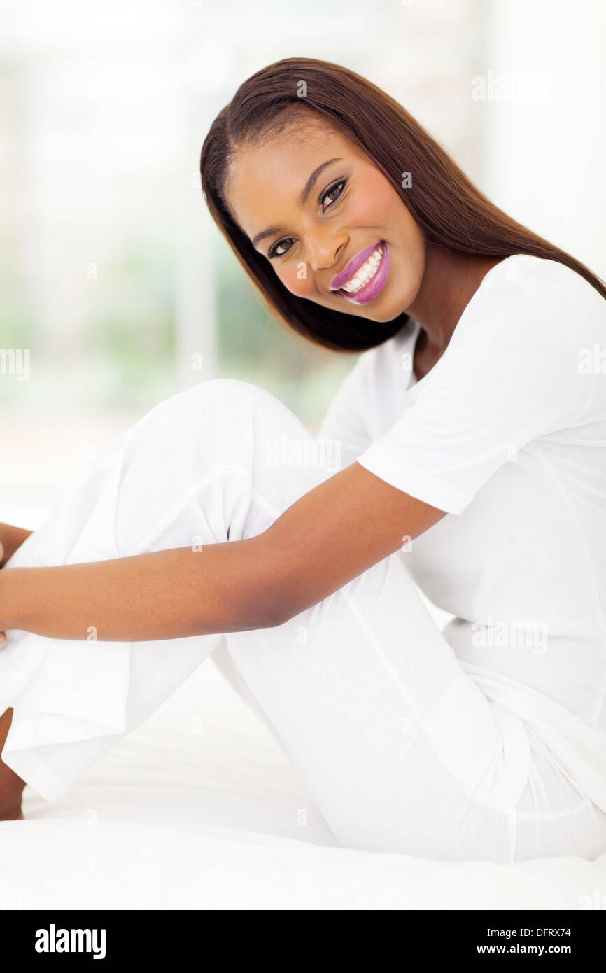portrait of pretty African woman sitting on bed Stock Photo - Alamy