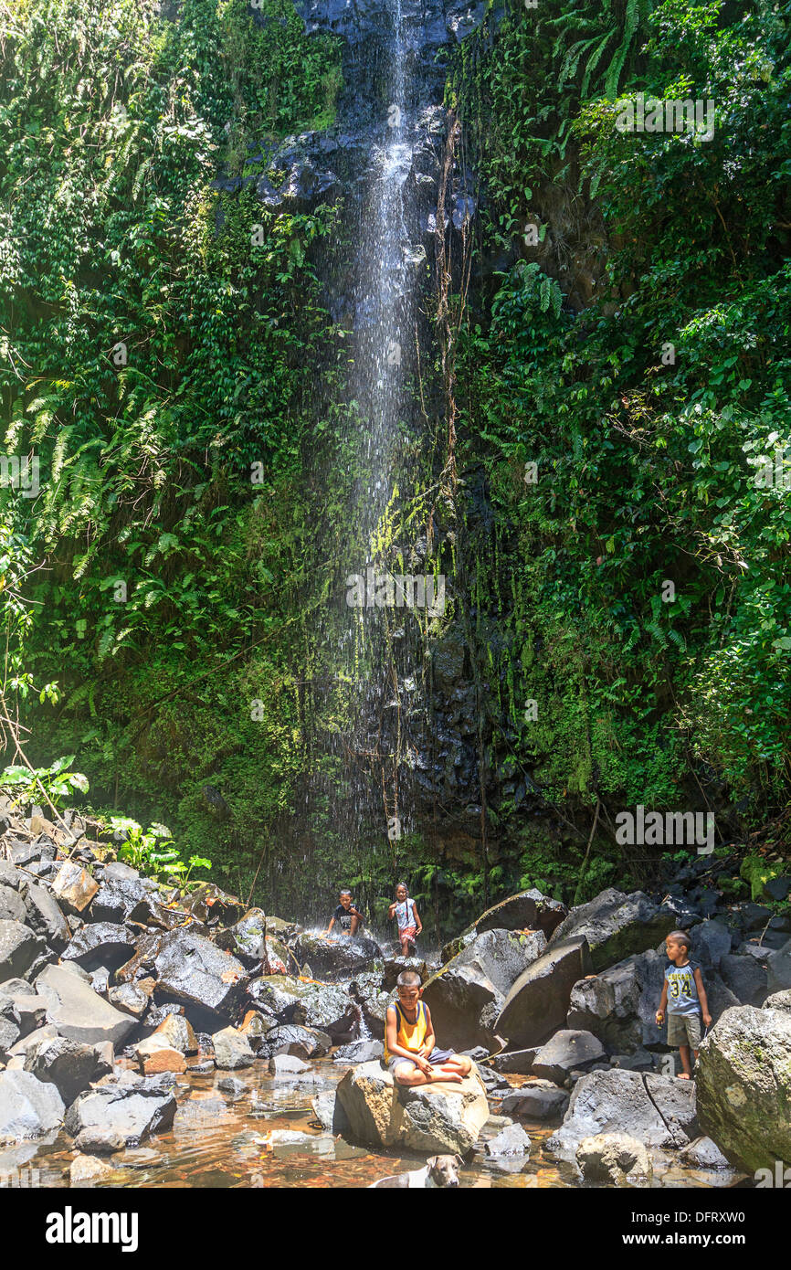 Young children play in cascading spray of Yekula waterfall on the island of Kosrae, Micronesia. Stock Photo