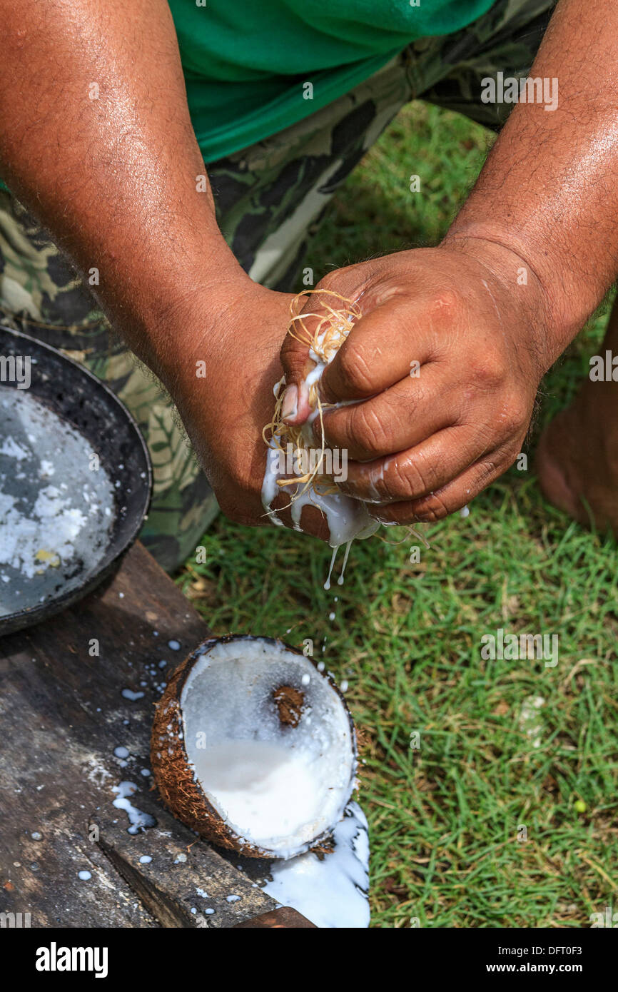 Local man demonstrates how to shred and strain fresh coconut to get coconut cream Stock Photo