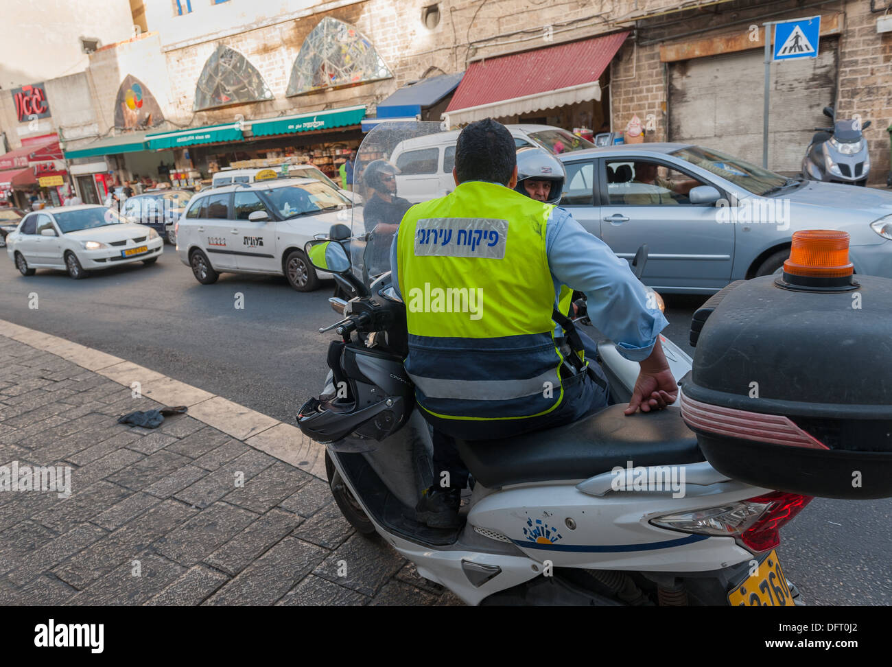 A city inspector watches over traffic and business in old Jaffa Israel Stock Photo
