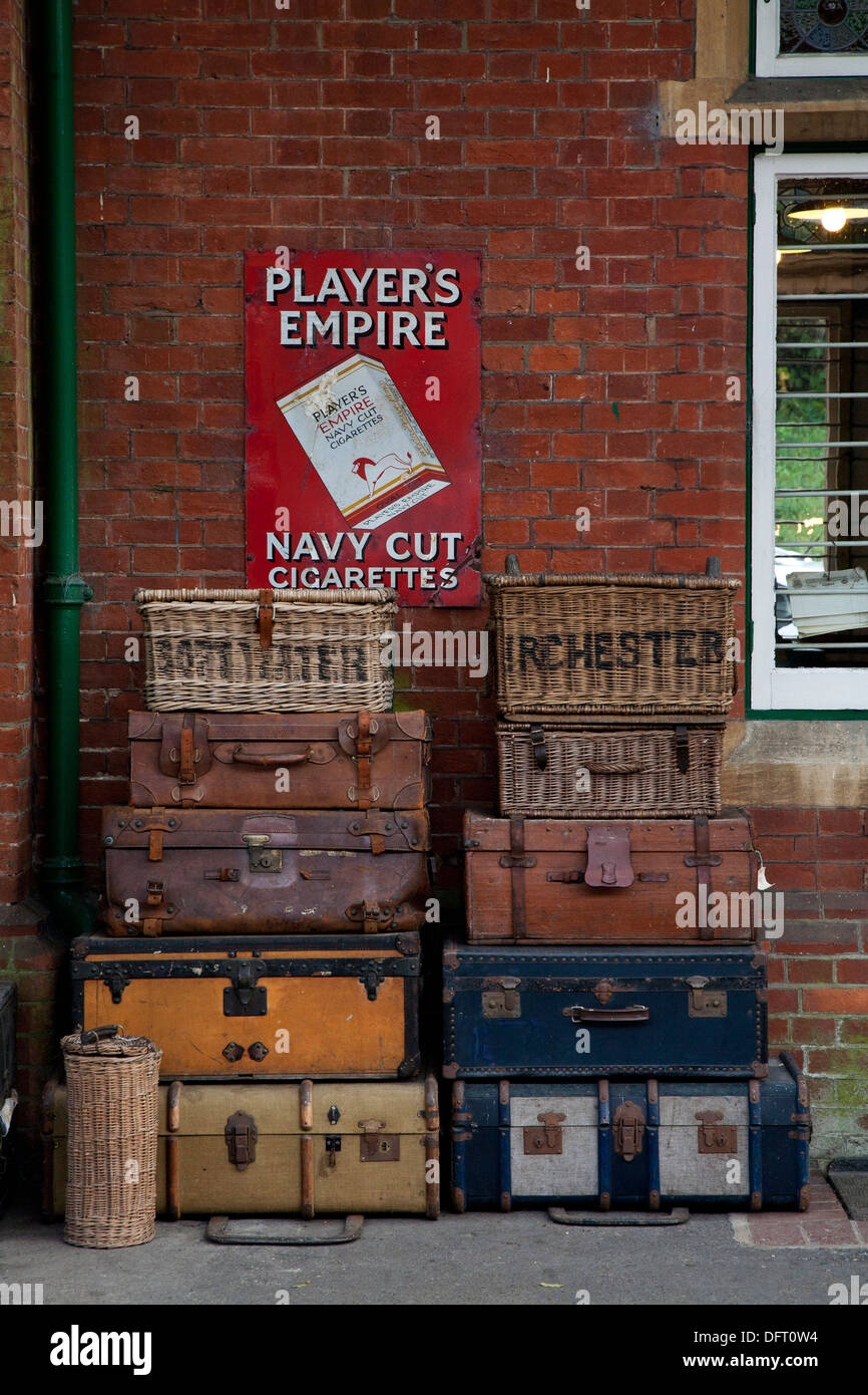 Vintage suitcases stacked against the wall and an old cigarette advert. Stock Photo