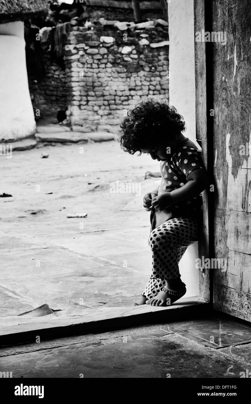 Young Indian girl standing at the doorway of her rural indian village house. Andhra Pradesh, India Stock Photo