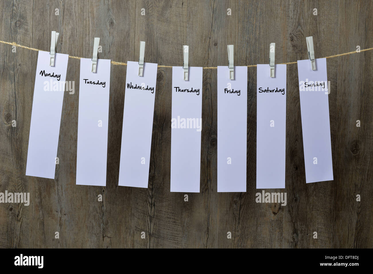 seven sheets of paper hanging on a clothesline Stock Photo