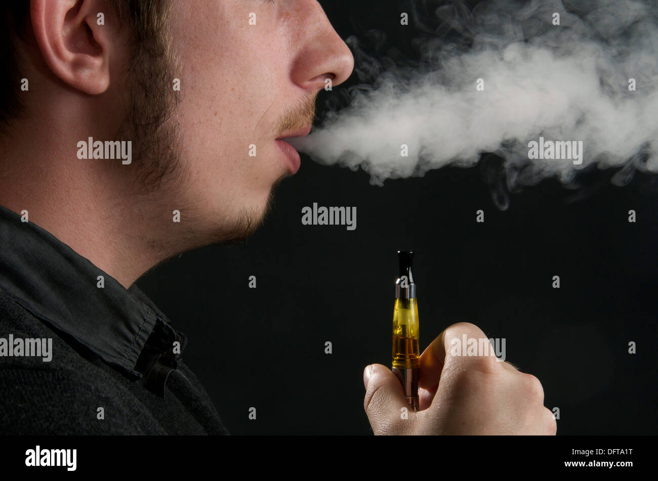 Man smoking an electronic cigarette and exhaling vapour Stock Photo