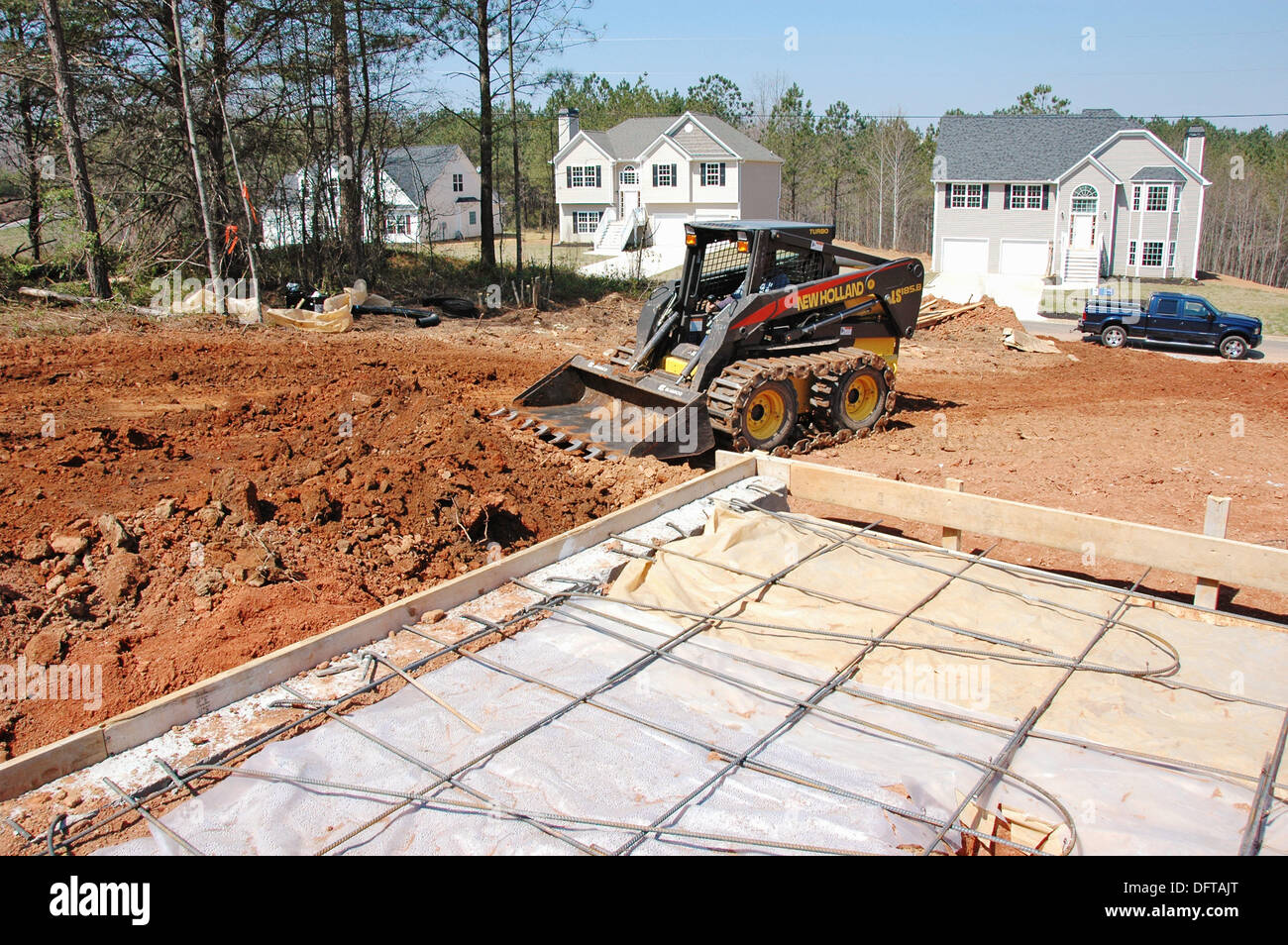 Bobcat dirt work around new foundation for new home construction Stock