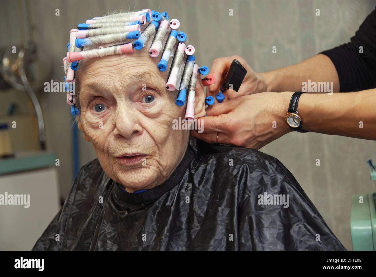 Senior elderly Woman has hair cut shampoo color and permanent done by