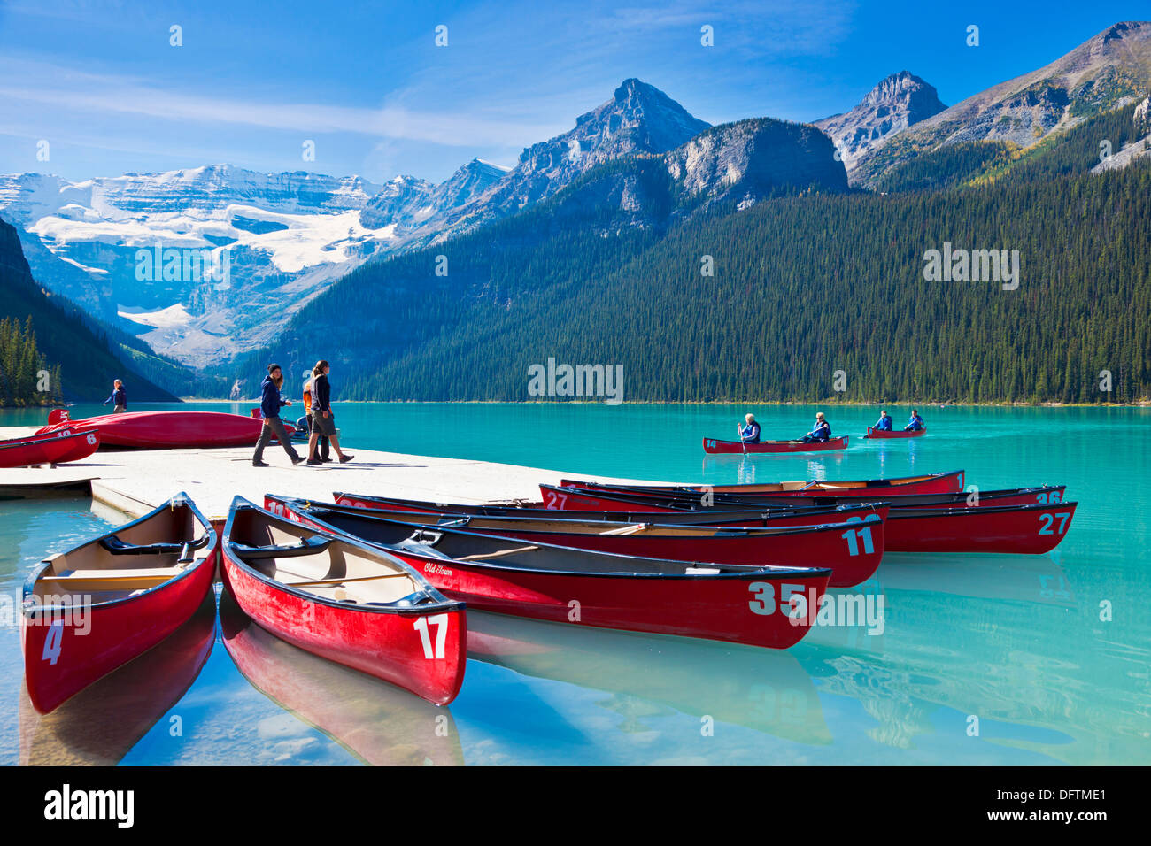 Red canoes for hire on Lake Louise Banff national Park Alberta Canadian Rockies Canada Stock Photo