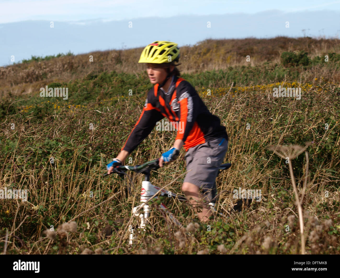 Teenage boy riding mountain bike along countryside footpath, Cornwall, UK Stock Photo