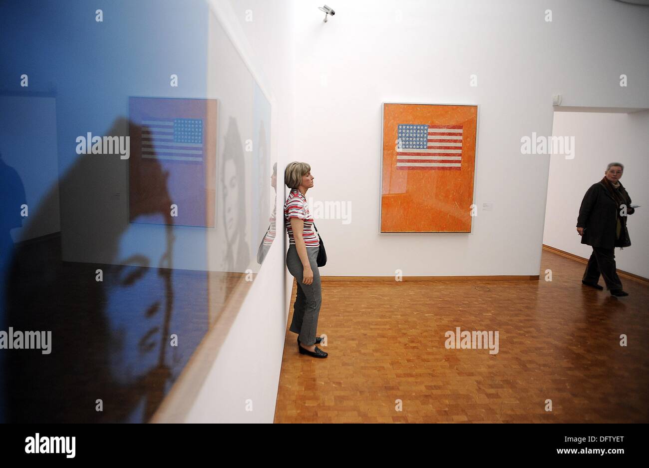 Cologne, Germany. 09th Oct, 2013. A visitor stands in the room with 'Jackie Triptych' (1964 - L) by Andy Warhol, the figure 'Woman with Handbag' (1974 - C) by Duane Hanson and 'Flag on Orange Field' (1959, R) by Jasper Johns during the preview of the new presentation of the collection under the title 'Not Yet Titled' (1964) at the Museum Ludwig in Cologne, Germany, 09 October 2013. The exhibition opens on 10 October 2013. Photo: HENNING KAISER/dpa/Alamy Live News Stock Photo