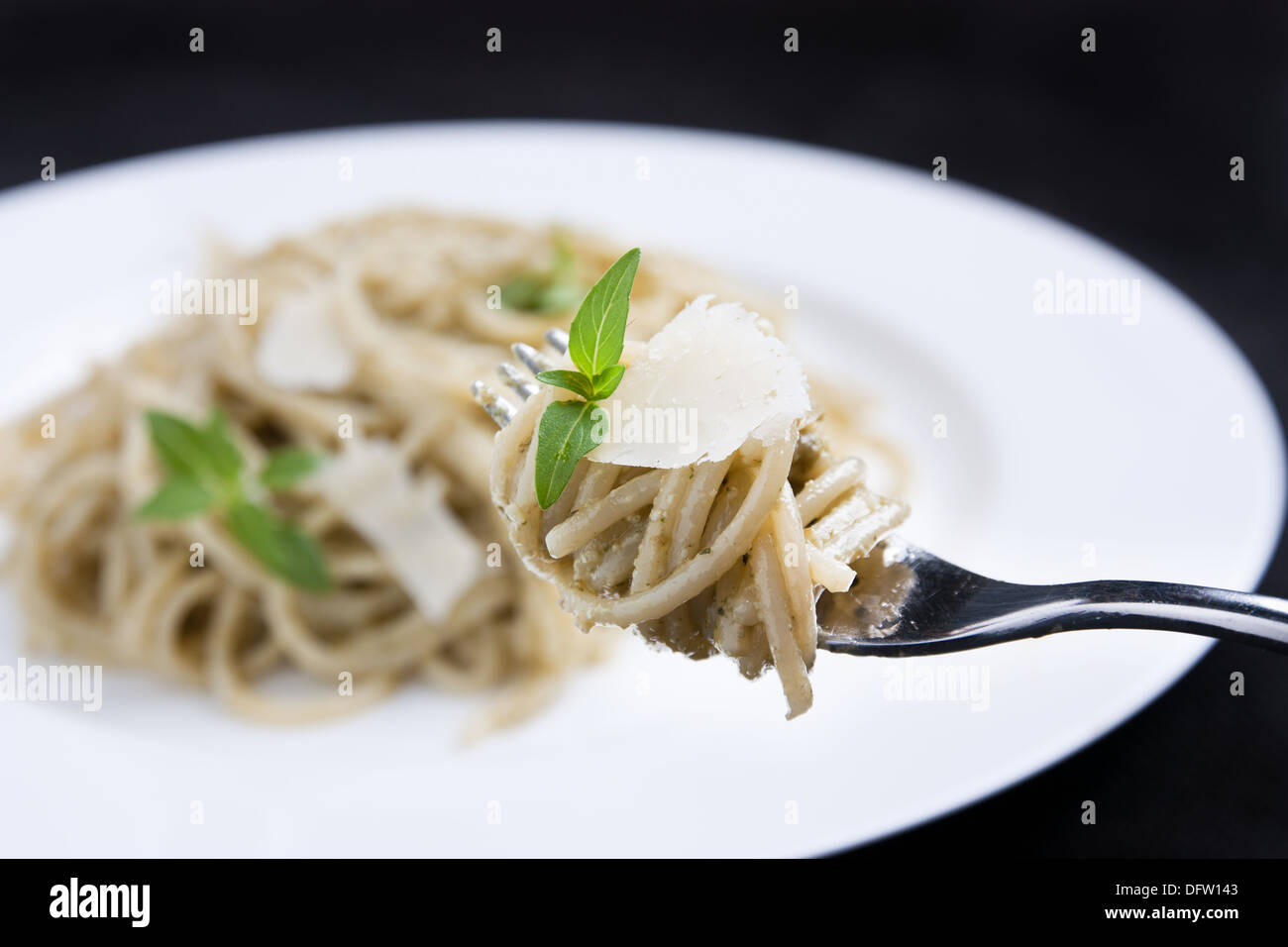 Spaghetti with cheese and basil on a fork Stock Photo