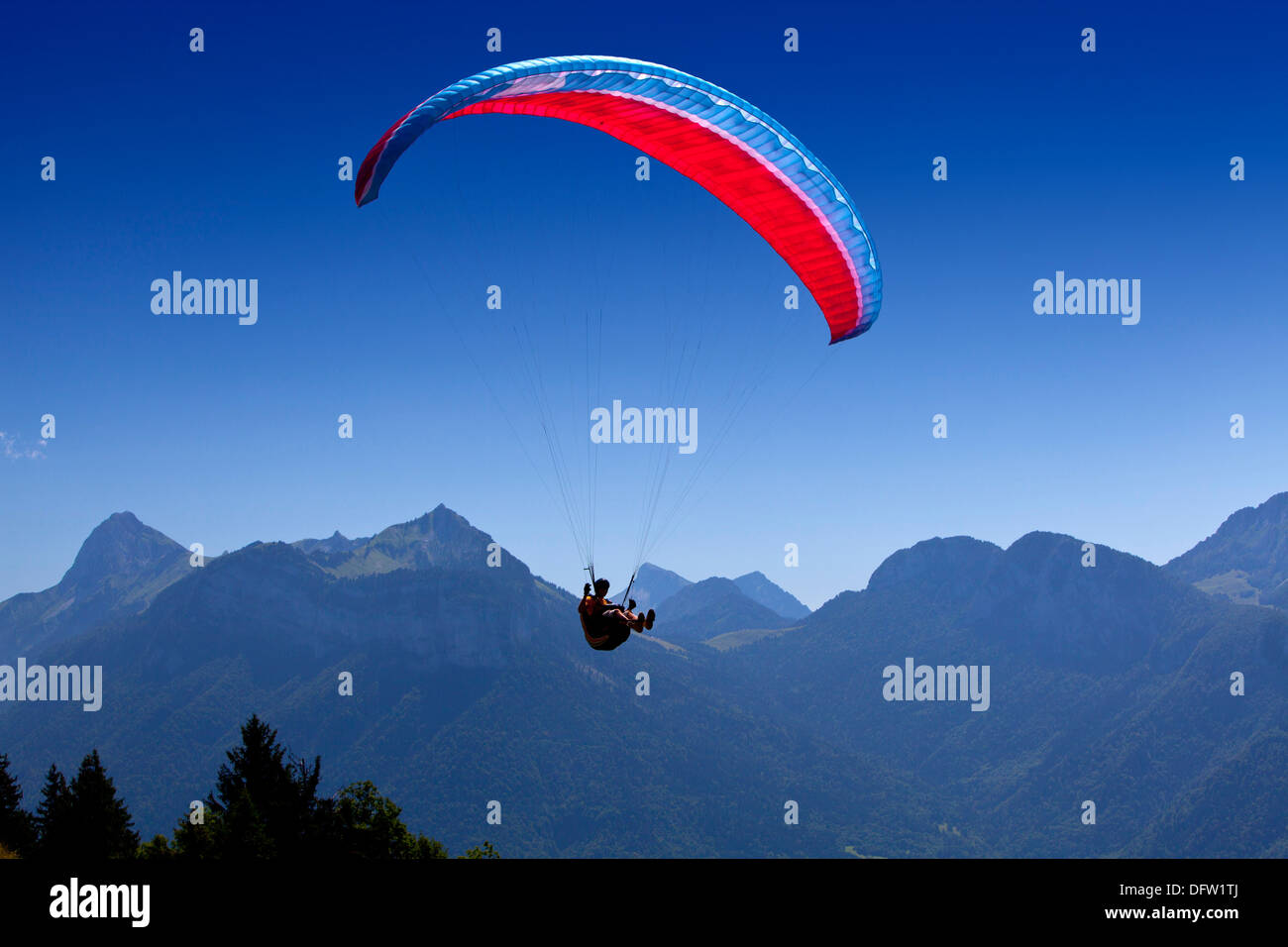 Para glider pilot flying his parachute over the mountains Stock Photo