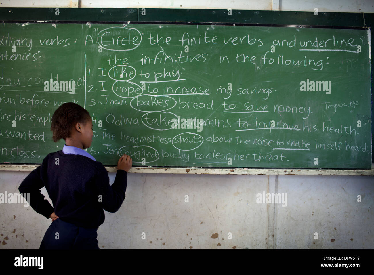 African schoolgirl writes on a chalkboard at Thandokhulli school, Mowbray, Cape Town. Stock Photo