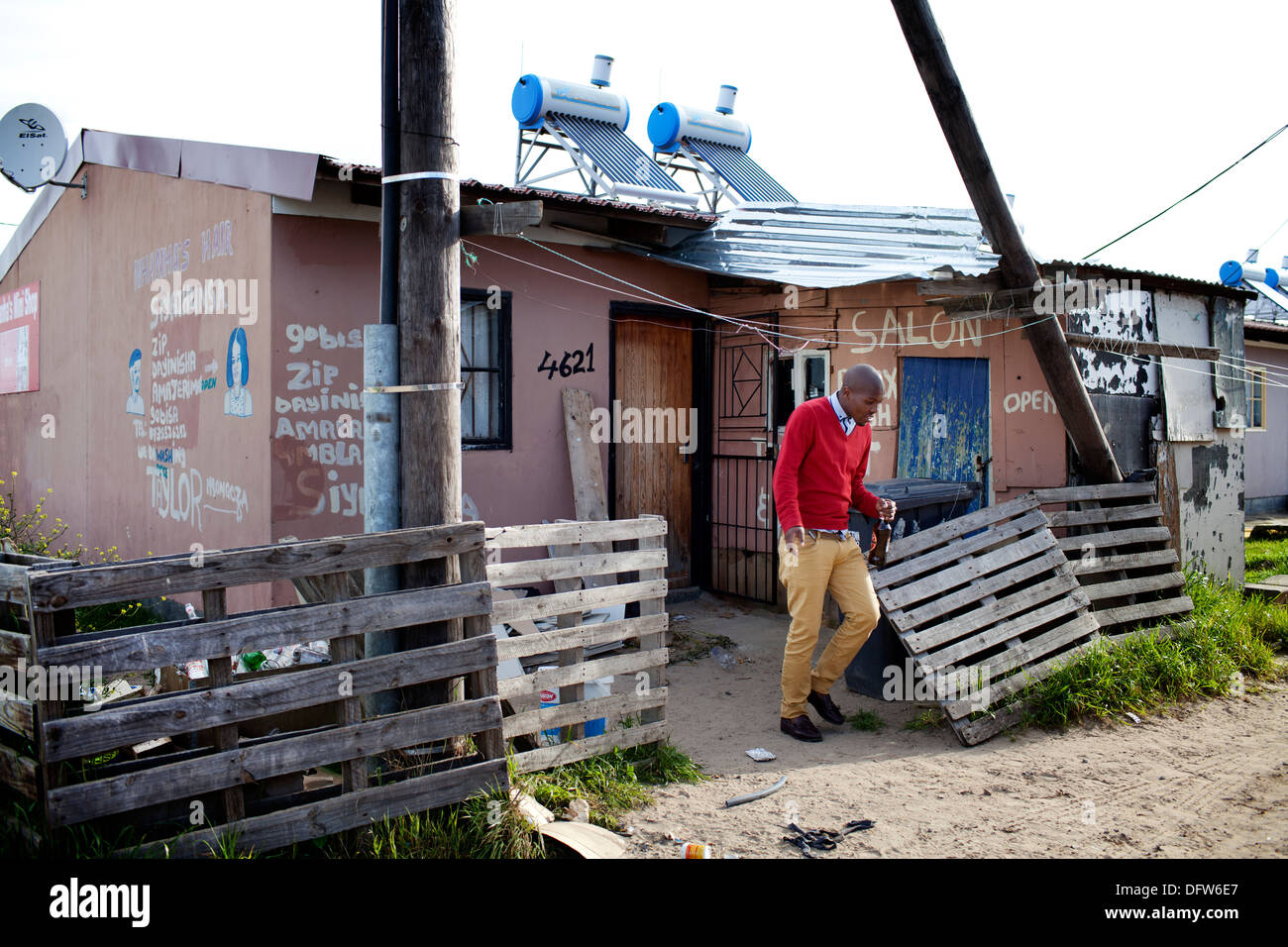 Cape Town South Africa - A man stands outside his home salon in a newly developed RDP housing project in Langa where all houses Stock Photo