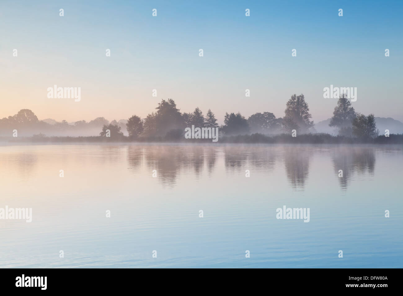 blue sky and morning fog over wild lake Stock Photo