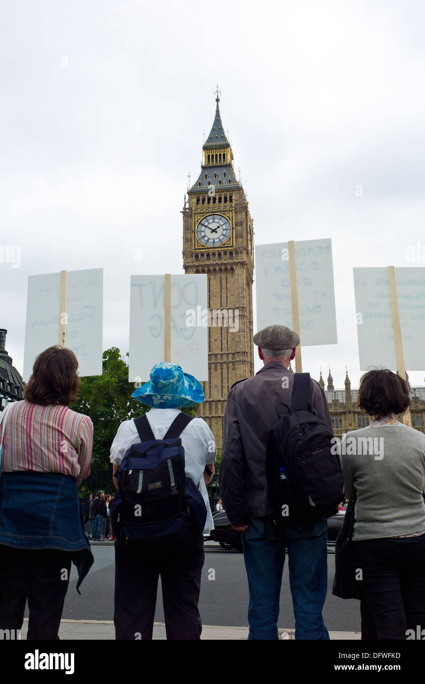 Protesters holding placards outside the Houses of Parliament in London UK Photo Credit: David Levenson / Alamy Stock Photo