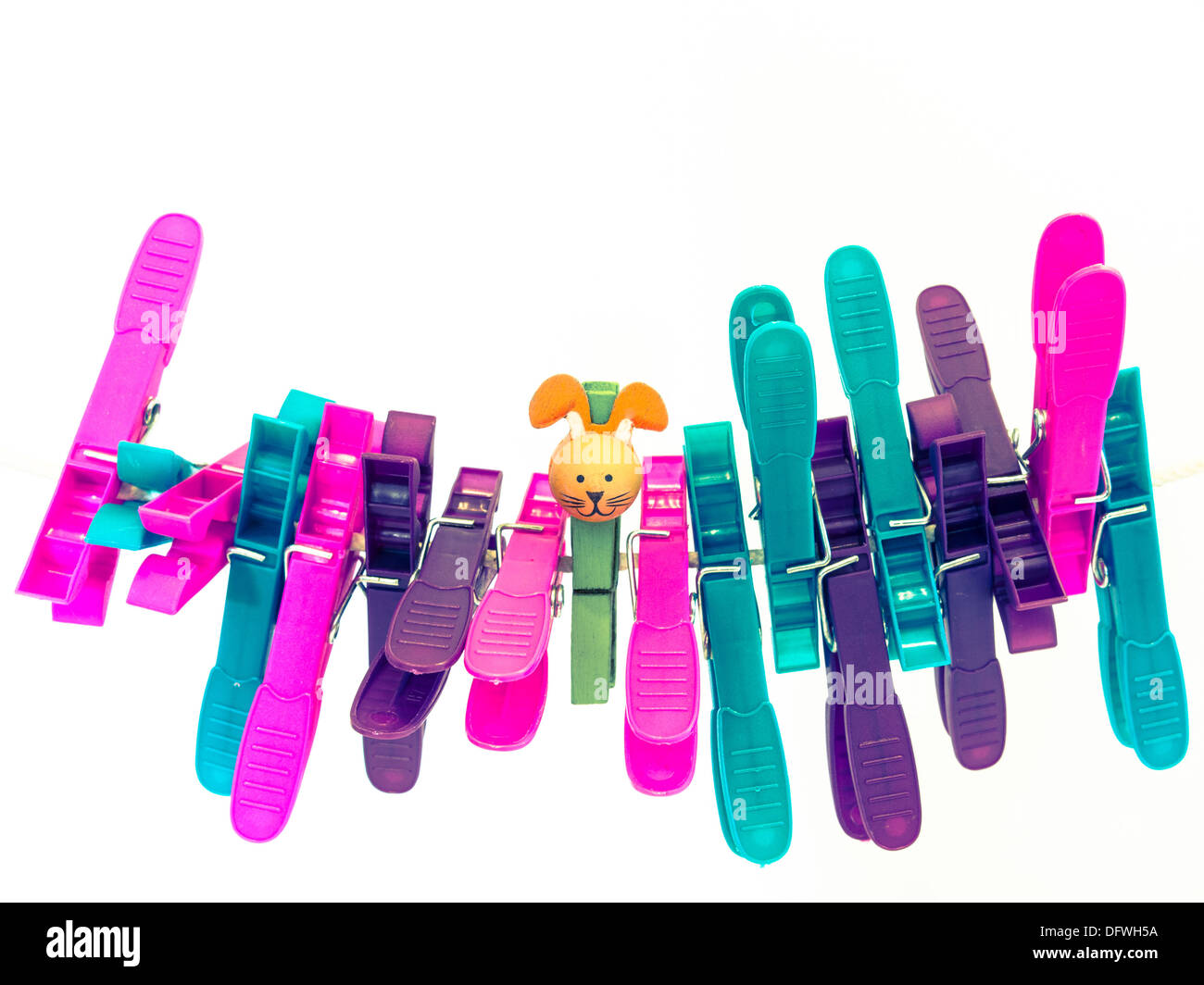 Colorful character plastic pegs on a line standing in a huddle with the central cute character Stock Photo