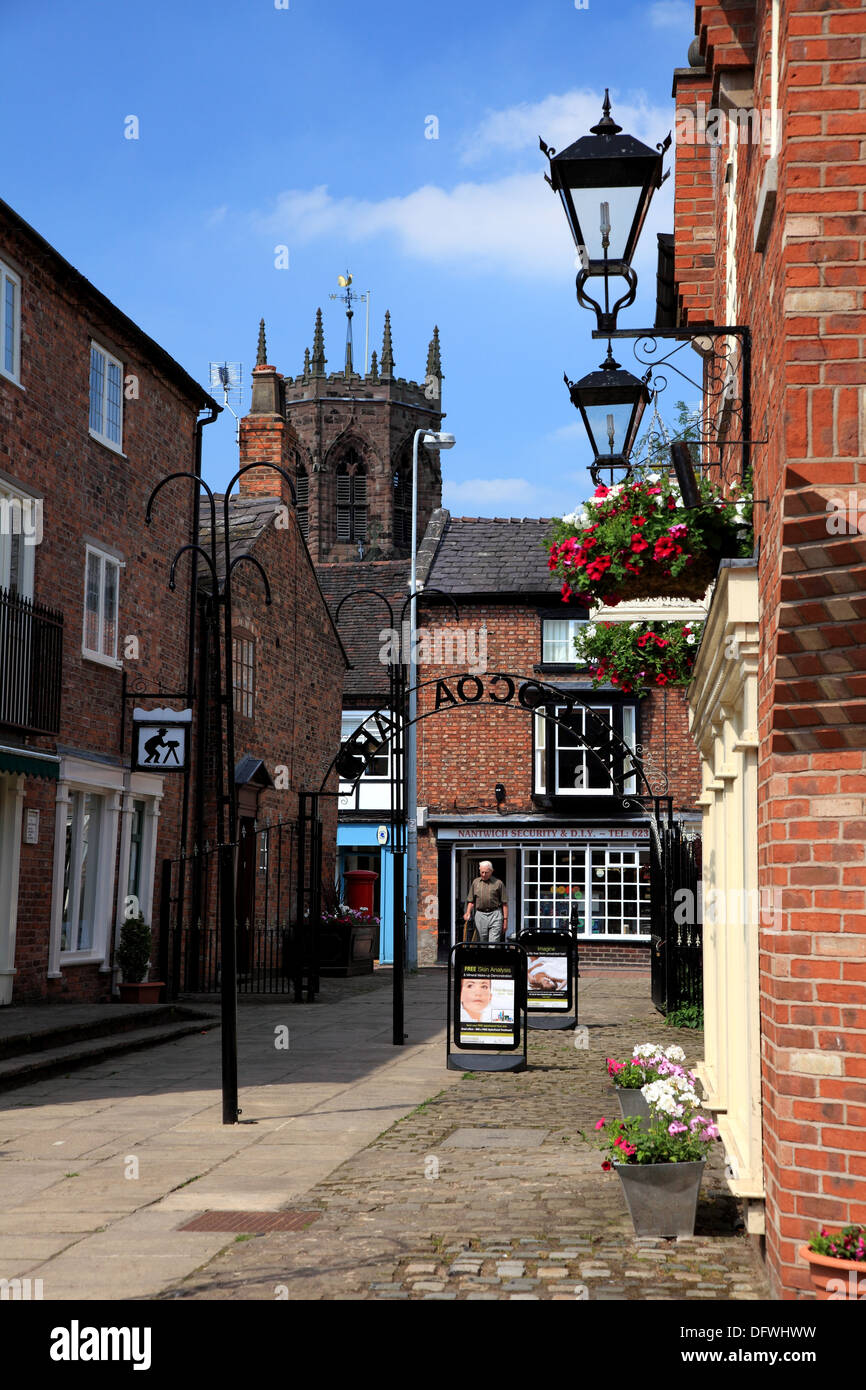 Cocoa Yard, Nantwich, a shopping arcade with small independent outlets and a view of the octagonal tower of St. Mary’s Church Stock Photo