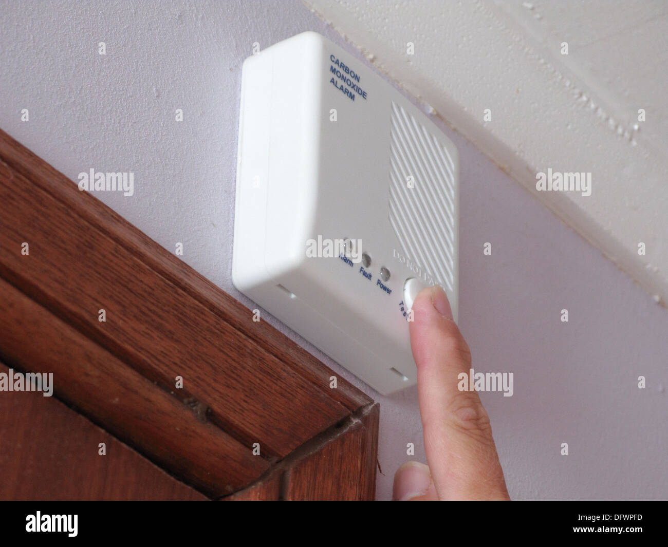 Caucasian Man Testing a Carbon Monoxide Monitor Alarm in a Home Setting, UK MODEL RELEASED Stock Photo