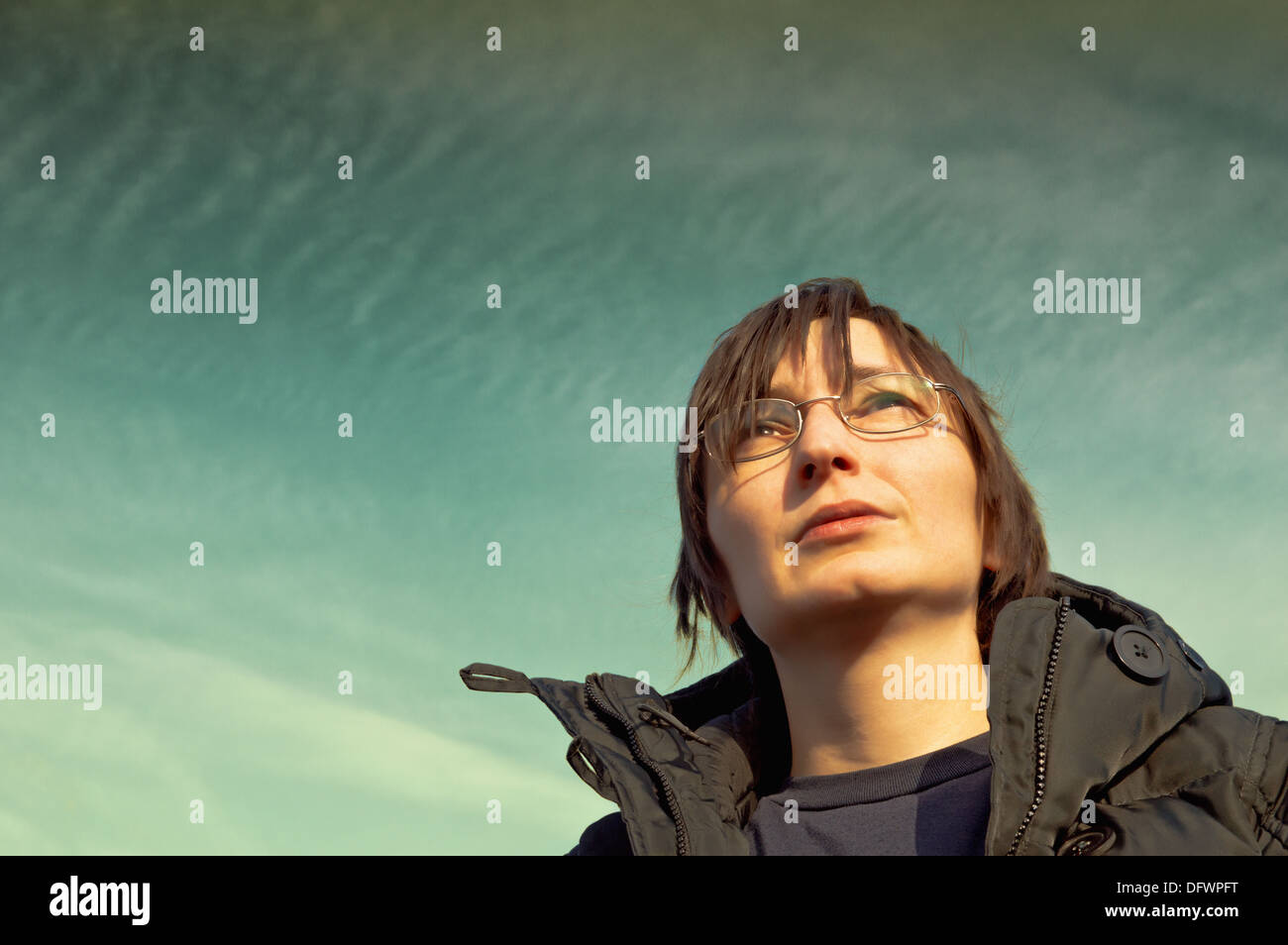 Adult woman looks at sky. Day dreaming. Stock Photo