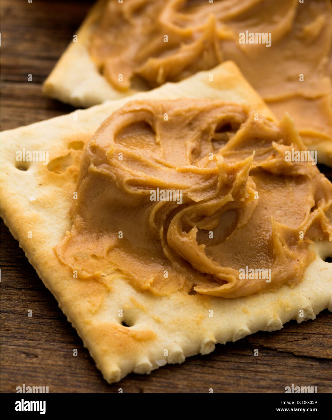 Peanut butter on crackers on weathered plank Stock Photo Alamy