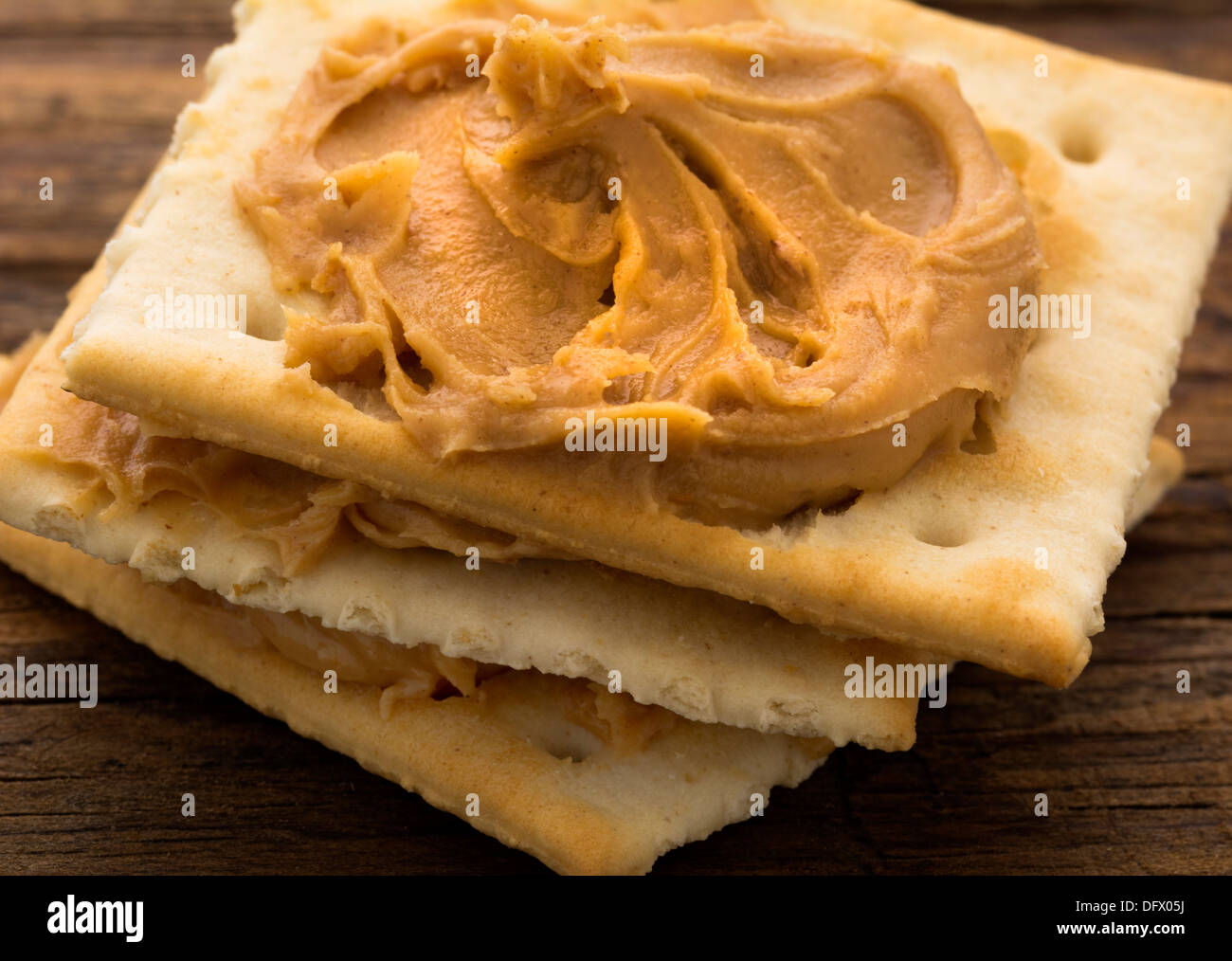 Peanut butter on crackers on weathered plank Stock Photo Alamy