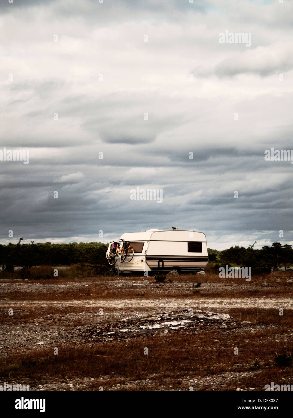 Camper Parked in Rocky Field Stock Photo