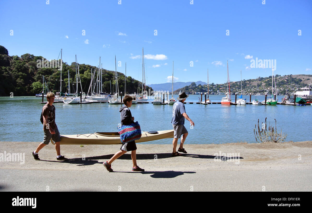 man and teenagers carry kayak at ayala cove on Angel island state park
