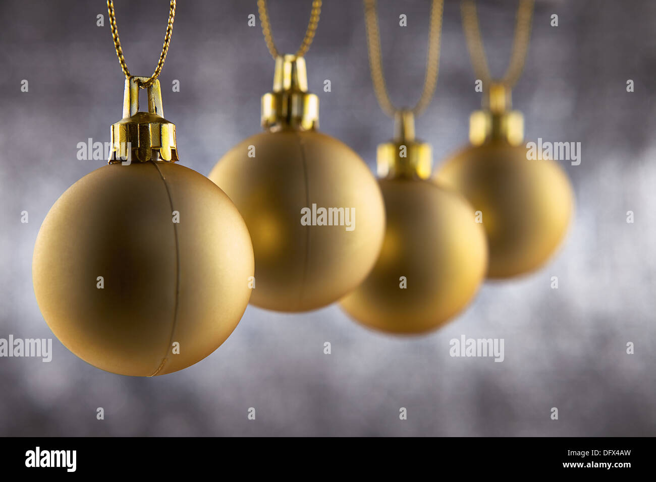 Four christmas decoration ball hanging against a silver glitter background with shallow depth of Field Stock Photo
