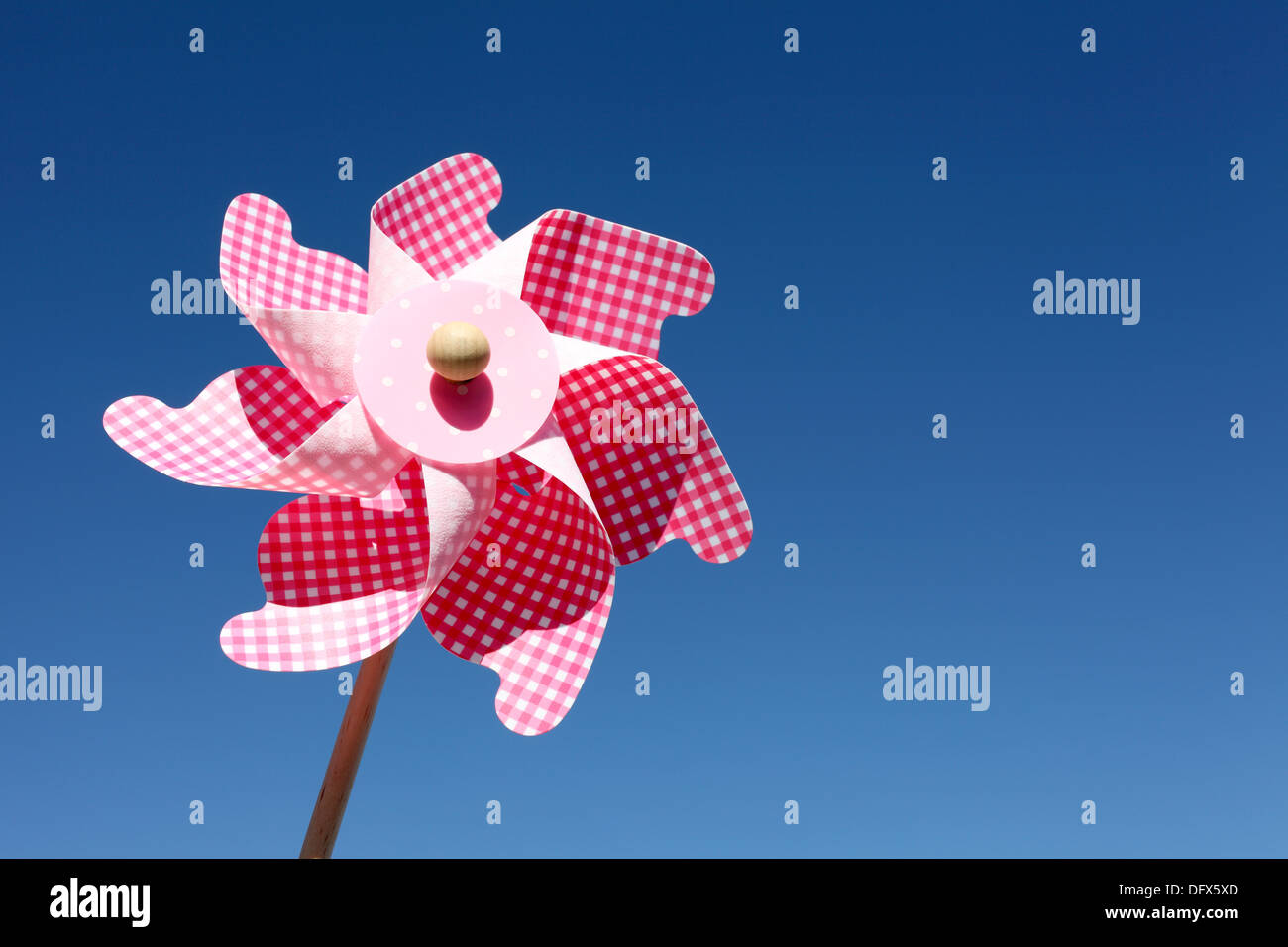 Colorful toy pinwheel against clear blue sky Stock Photo