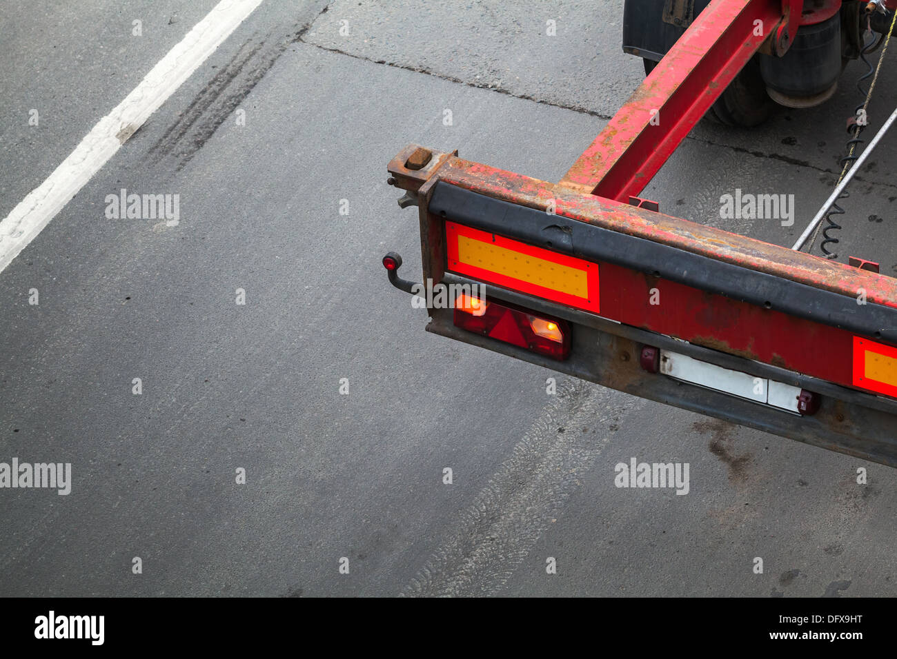 Back part with taillight of empty truck cargo trailer on the asphalt road Stock Photo