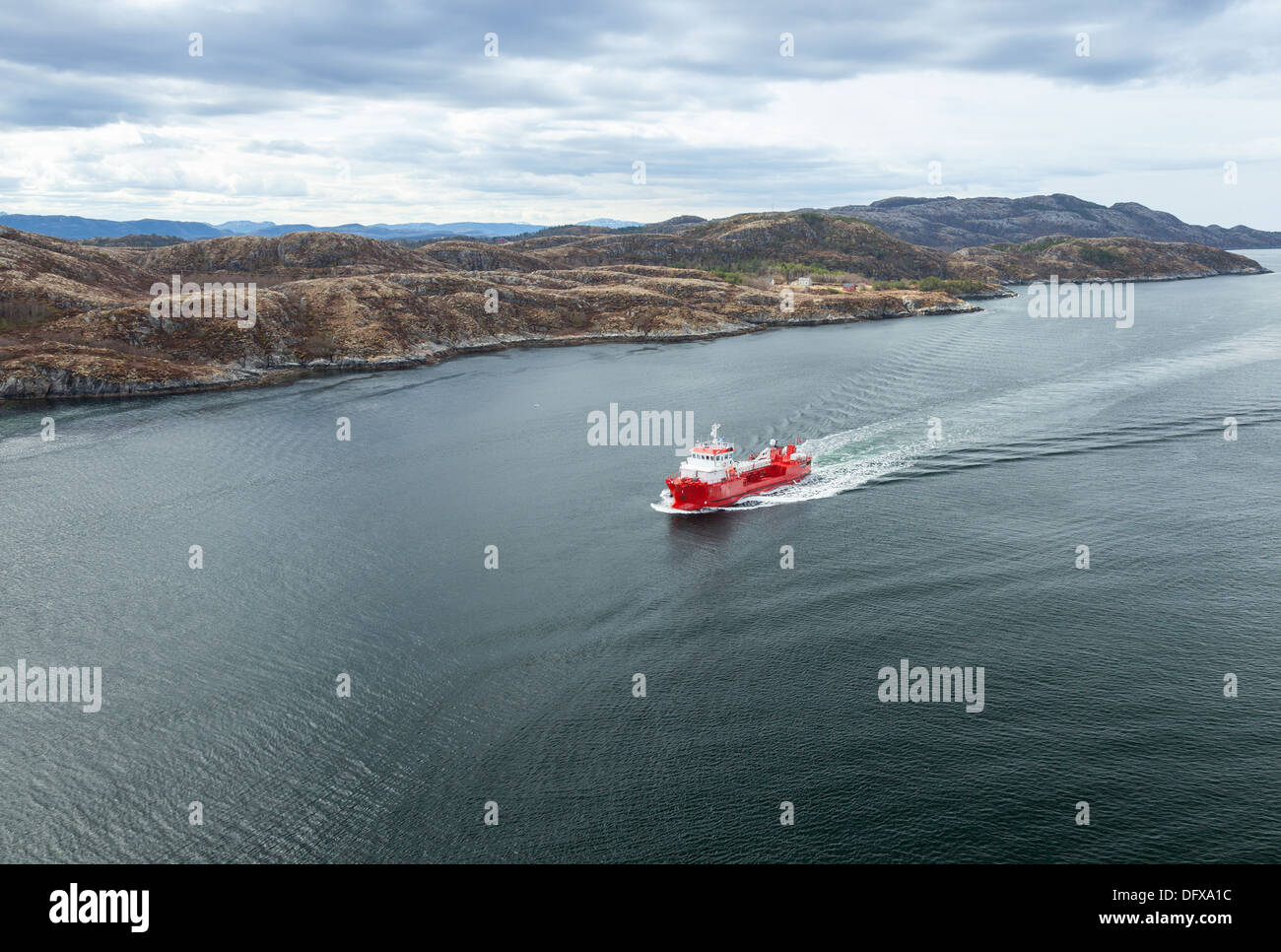 Small Norwegian red oil products tanker ship sails in the fjord Stock Photo