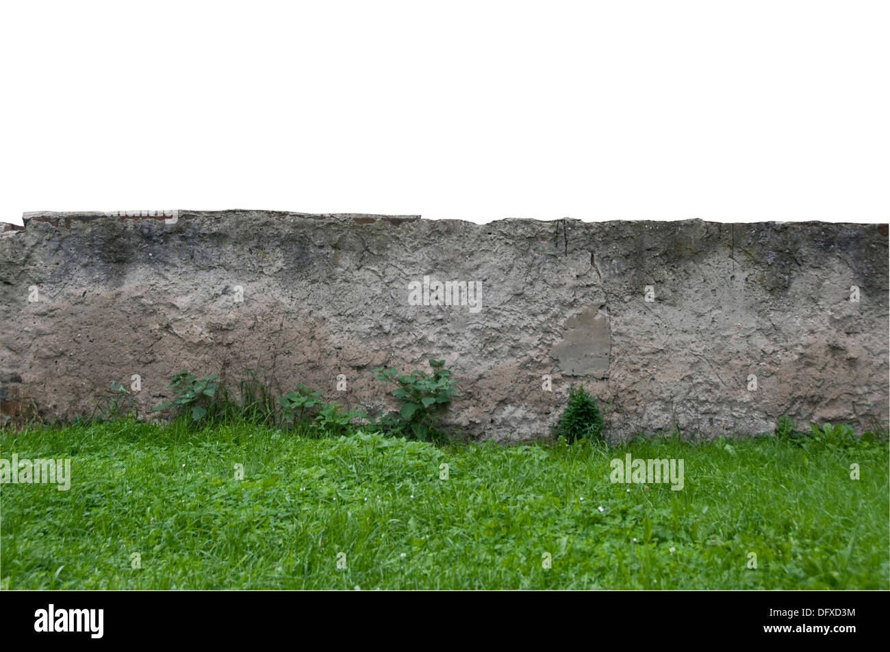 old concrete wall in decay, with grass in front Stock Photo