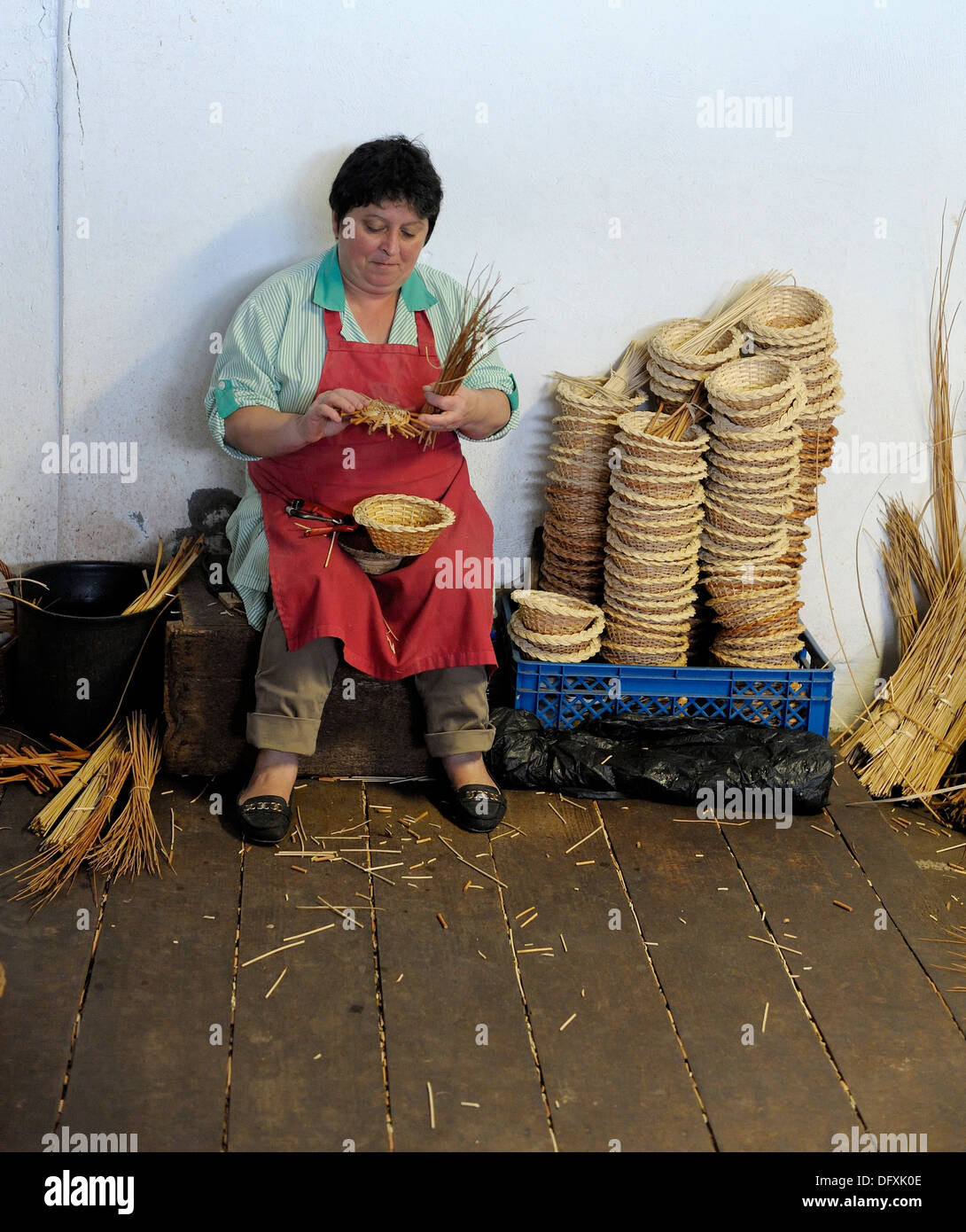 A Female basket weaver at work in the factory shop in Camacha Madeira