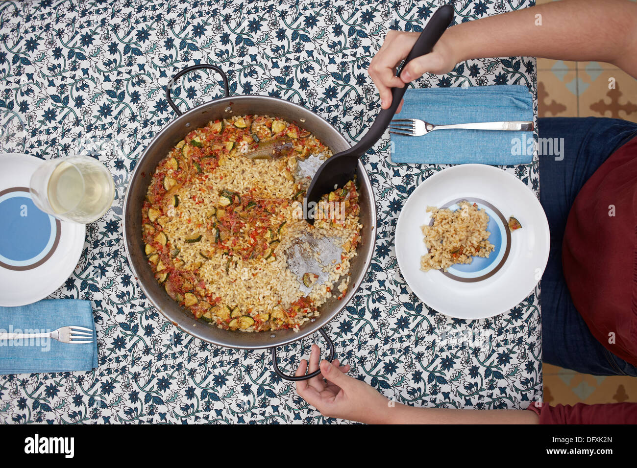 Woman's hands serving rice with vegetables on a dish Stock Photo - Alamy