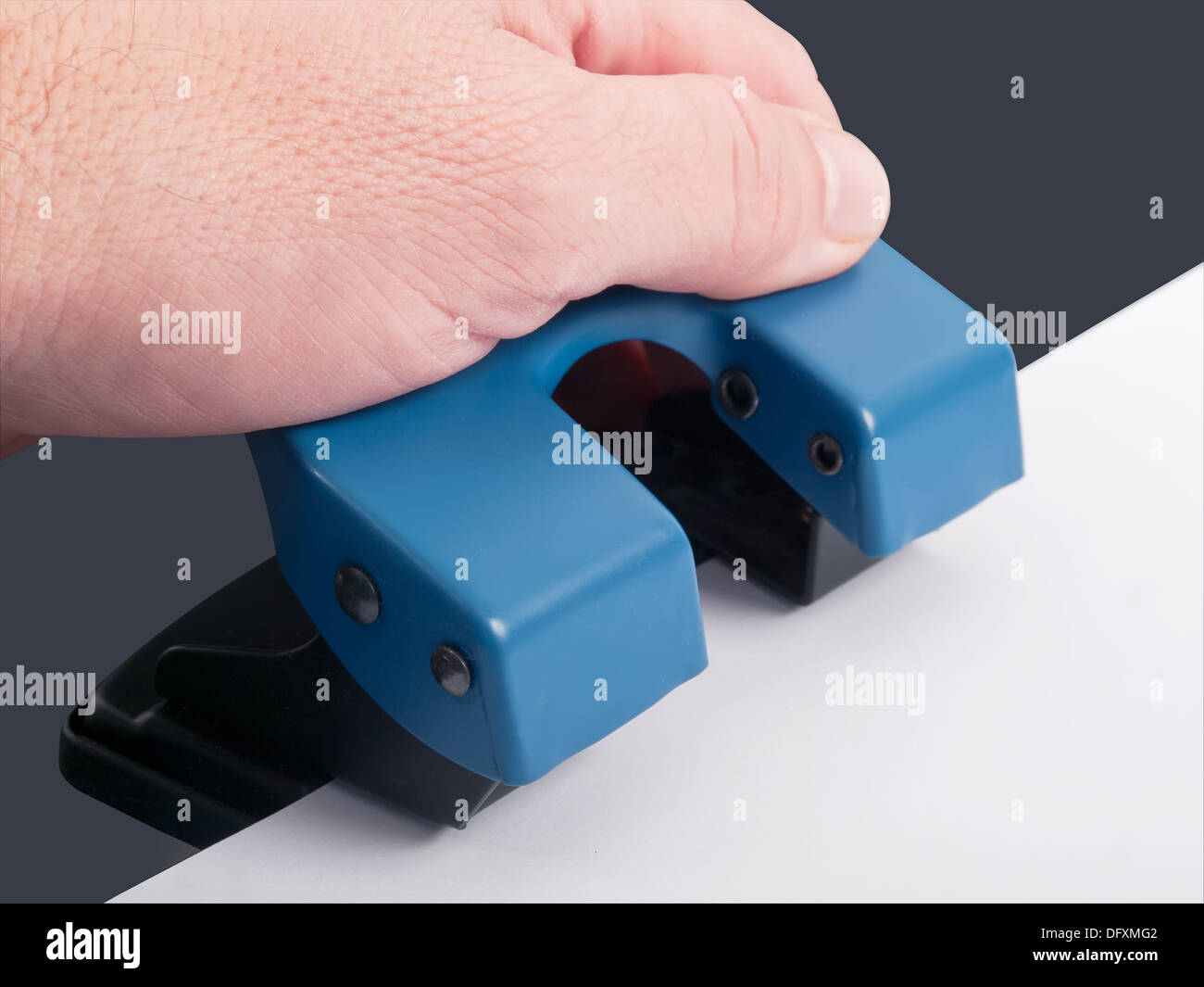 drilling hole punch with paper, studio shot Stock Photo
