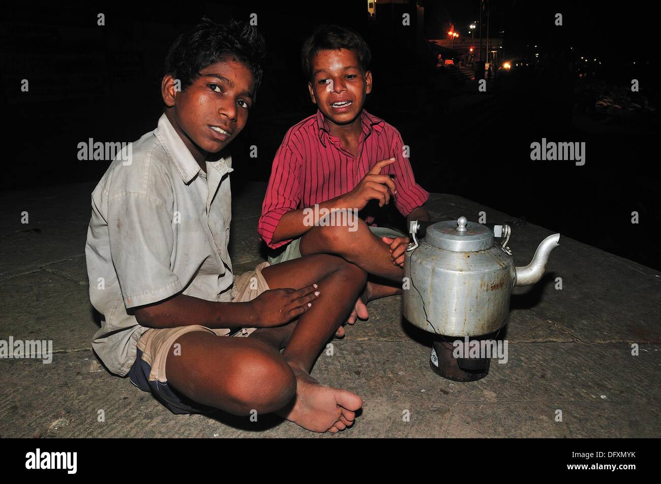 Young brothers sell post card in the day time  Late afternoon sells flowers to pilgrims  At night sells hot tea in the dark Stock Photo