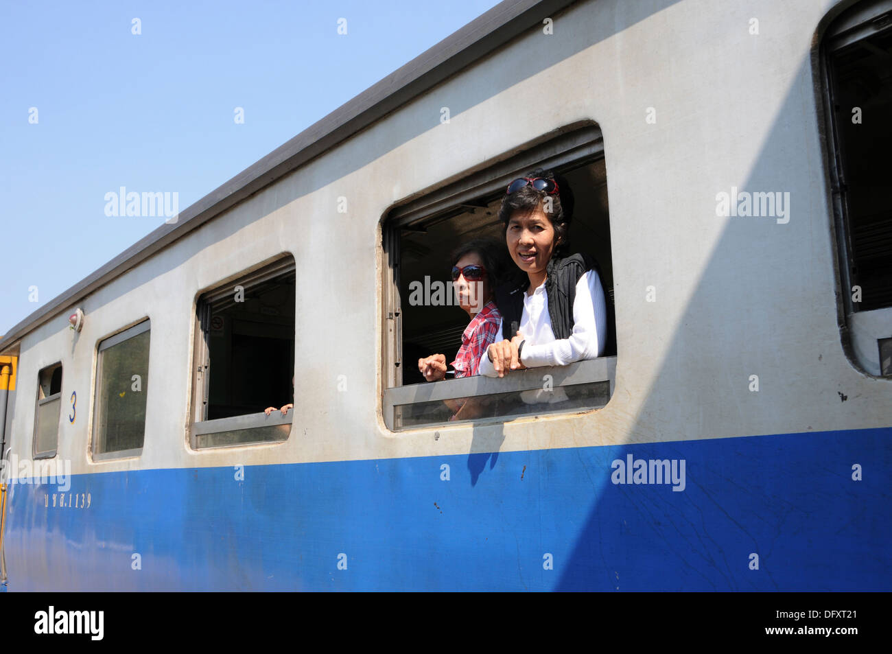 Two Thai women look out a train window Stock Photo - Alamy