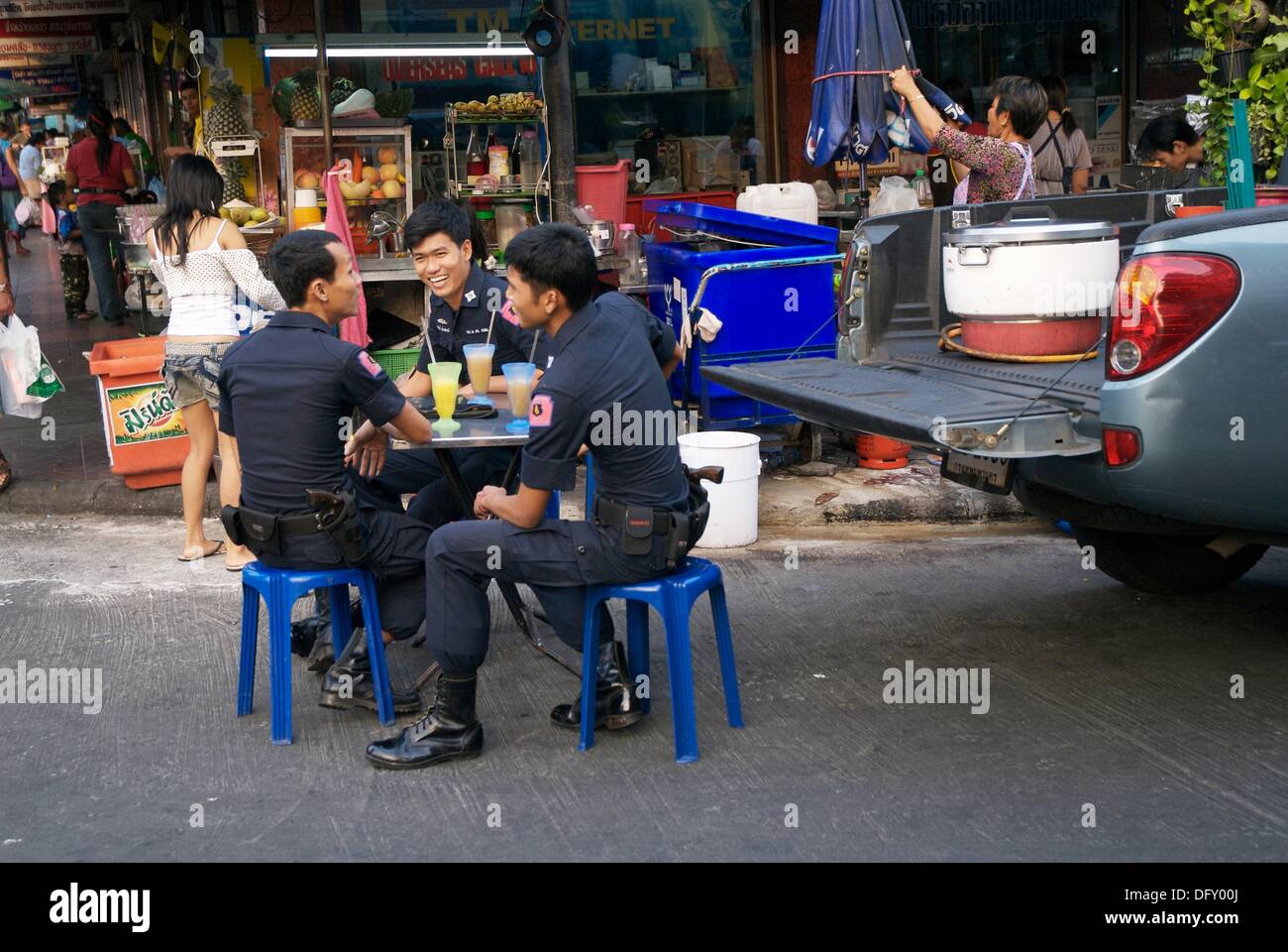 Three Thai Police Man enjoy Fruit Shake in Soi Rambuttri in Bangkok Stock Photo