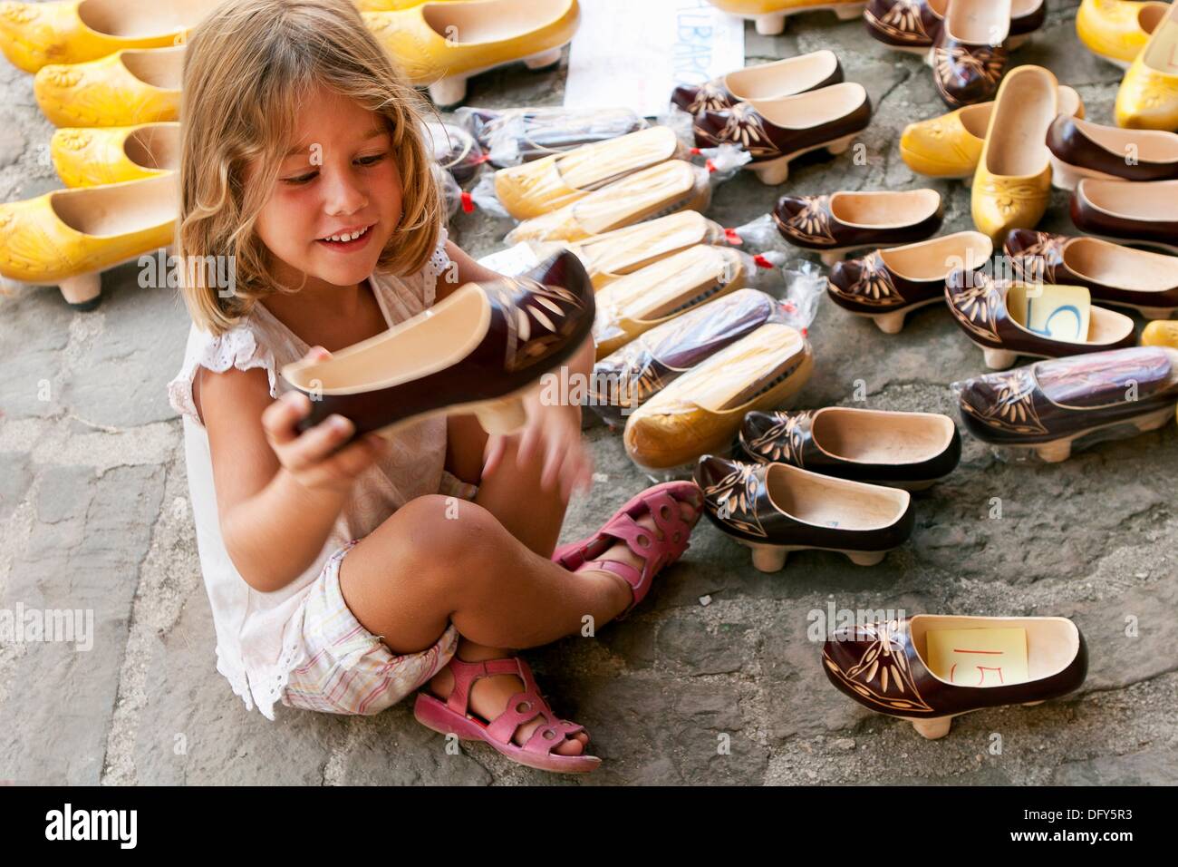 Girl sitting on the floor picking up a shoe Stock Photo Alamy