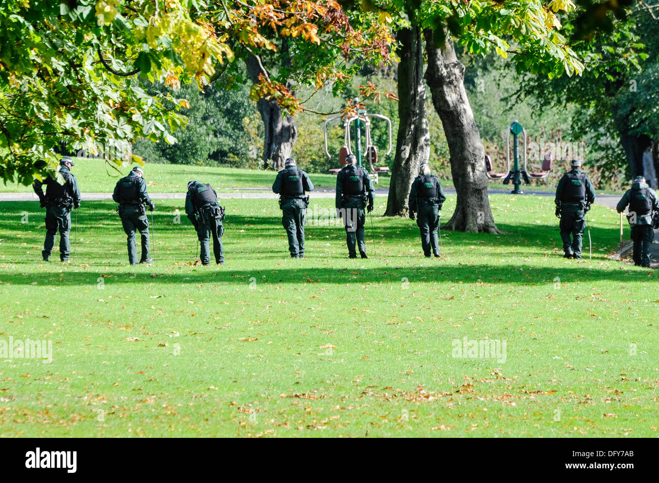 Belfast, Northern Ireland, UK. 10th Oct 2013 - PSNI officers conduct a thorough search of an area of grass in a park Stock Photo