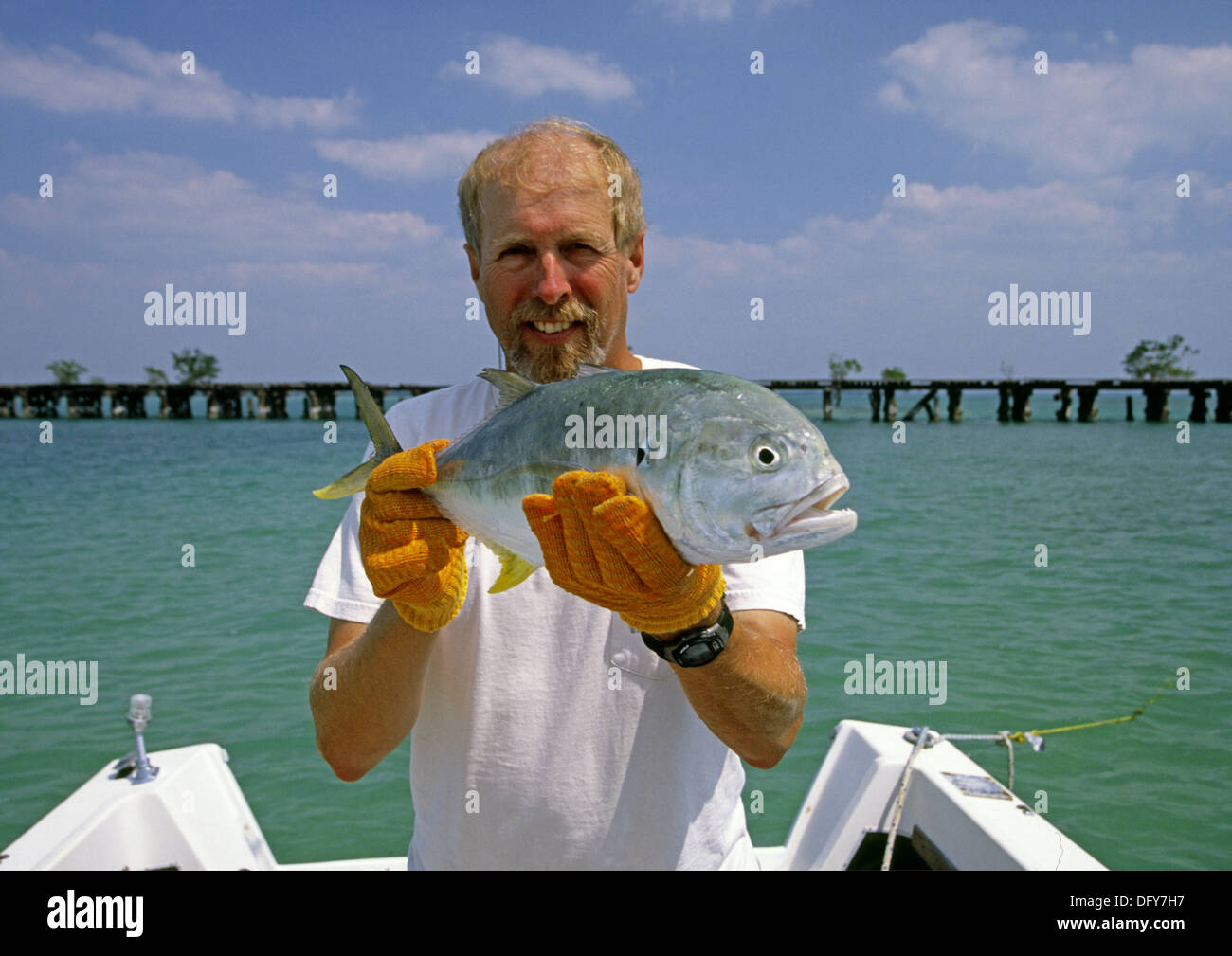 Fisherman holding a crevalle jack fish in Charlotte harbor in Florida