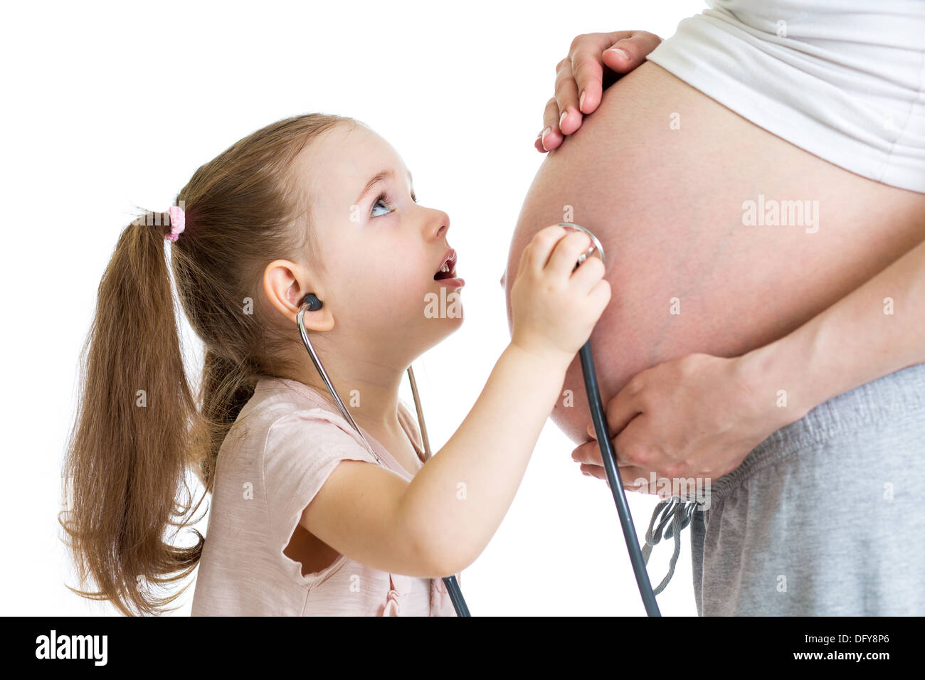 kid girl listening to mother's tummy Stock Photo