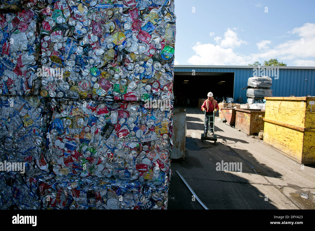 crushed and compacted cubes of metal and aluminum cans at a scrap metal