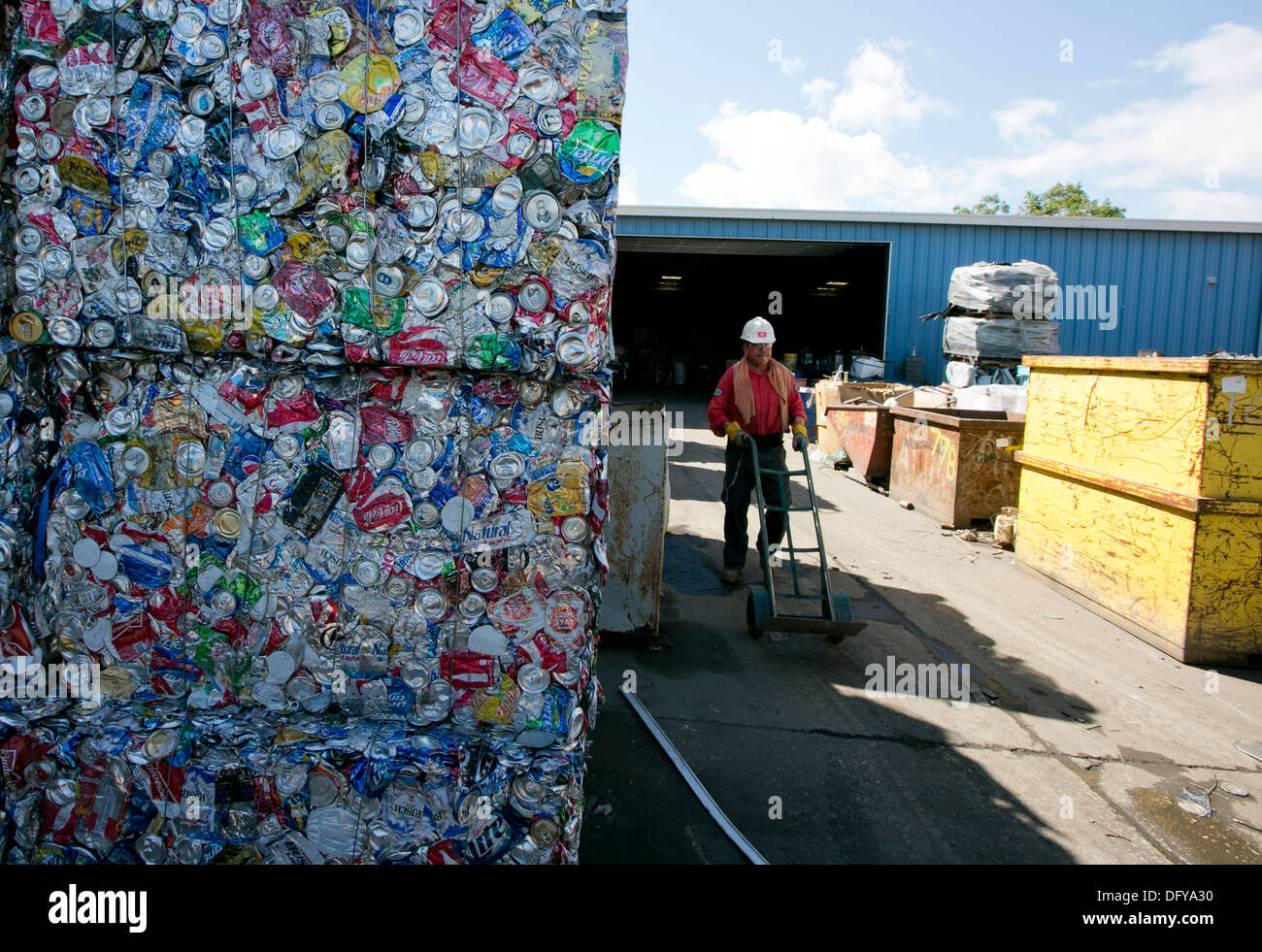 crushed and compacted cubes of metal and aluminum cans at a scrap metal