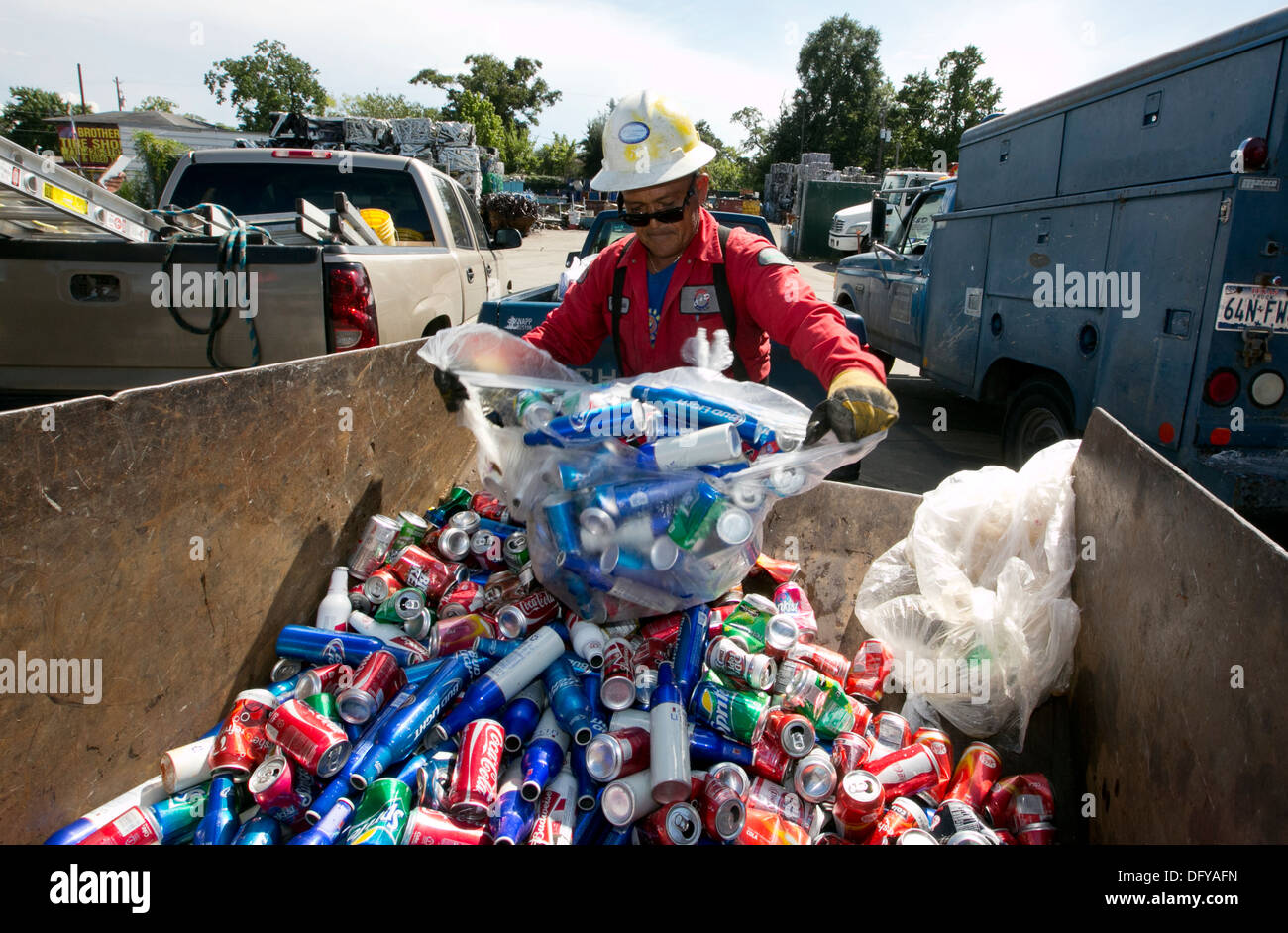 Worker at scrap metal recycling plant empties bag of cans, beer cans, soda cans in Texas Stock