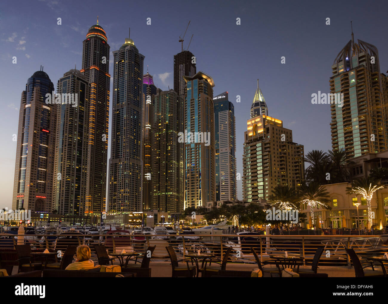Night cityscape and outdoor restaurant on the promenade that meanders around Dubai Marina, Dubai, UAE Stock Photo