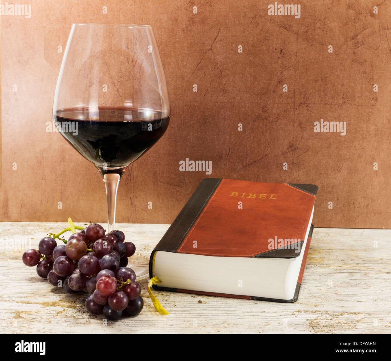 old bible and red wine with grapes on table Stock Photo